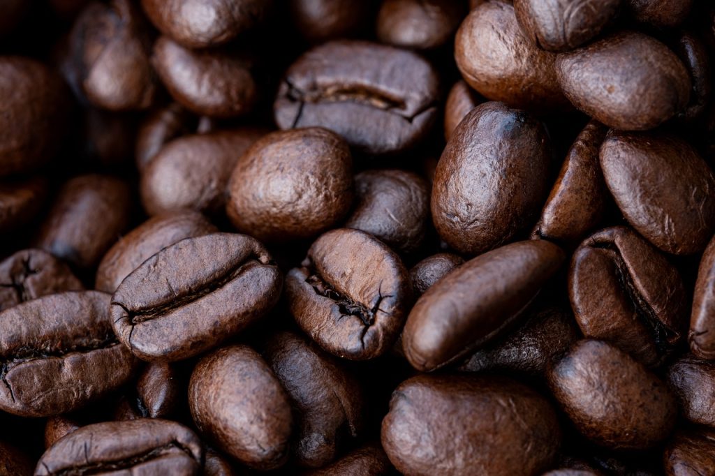 the essence of Ruiru Coffee Beans: a close-up shot of freshly roasted beans, their rich, chocolatey aroma wafting through the air